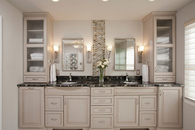 Example of a mid-sized transitional master mosaic tile porcelain tile and beige floor corner shower design in Baltimore with raised-panel cabinets, white cabinets, beige walls, an undermount sink, granite countertops and a hinged shower door