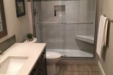 Inspiration for a mid-sized transitional 3/4 medium tone wood floor alcove shower remodel in Calgary with gray walls, shaker cabinets, dark wood cabinets and an undermount sink