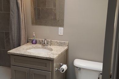 Small transitional kids' gray tile and porcelain tile vinyl floor bathroom photo in Indianapolis with shaker cabinets, gray cabinets, a two-piece toilet, gray walls, an undermount sink and granite countertops