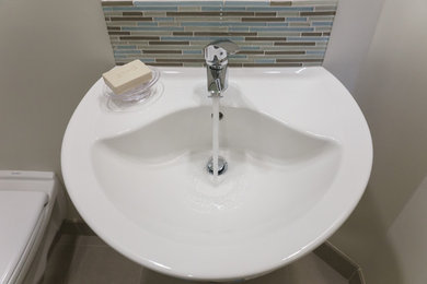 Example of a small beach style 3/4 multicolored tile and glass tile ceramic tile double shower design in Vancouver with a wall-mount sink, flat-panel cabinets, white cabinets, a wall-mount toilet and beige walls