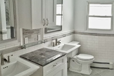 ニューヨークにある低価格の中くらいなトラディショナルスタイルのおしゃれなバスルーム (浴槽なし) (ペデスタルシンク、グレーのタイル、白い壁、セラミックタイルの床、レイズドパネル扉のキャビネット、白いキャビネット、大理石の洗面台、ドロップイン型浴槽、オープン型シャワー、分離型トイレ、サブウェイタイル) の写真