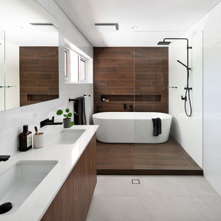 Inspiration for a contemporary bathroom in Perth with flat-panel cabinets, dark wood cabinets, a freestanding tub, brown tile, an undermount sink, grey floor and white benchtops.