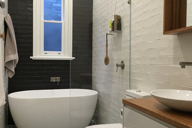 シドニーにある小さなトラディショナルスタイルのおしゃれな浴室 (白いキャビネット、白いタイル、磁器タイル、白い壁、磁器タイルの床、木製洗面台) の写真