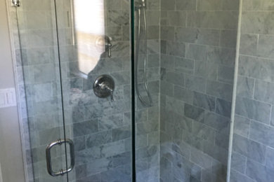 Idee per una piccola stanza da bagno con doccia chic con doccia ad angolo, piastrelle grigie, piastrelle in pietra, pareti beige e porta doccia a battente