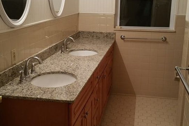 Mid-sized bathroom photo in Other with medium tone wood cabinets and granite countertops