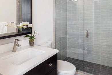 Alcove shower - transitional gray tile and white tile white floor alcove shower idea in New York with flat-panel cabinets, dark wood cabinets, white walls, a drop-in sink, quartz countertops and a hinged shower door