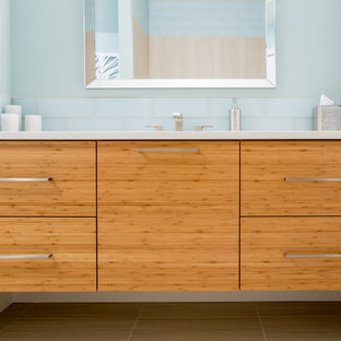 Idee per una piccola stanza da bagno minimalista con ante lisce, ante in legno chiaro, piastrelle blu, piastrelle di vetro, pareti blu, pavimento con piastrelle in ceramica, lavabo sottopiano, top in quarzo composito e pavimento grigio