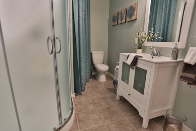 Example of a small transitional 3/4 gray tile and porcelain tile porcelain tile corner shower design in Other with an integrated sink, shaker cabinets, white cabinets, quartzite countertops, a two-piece toilet and blue walls