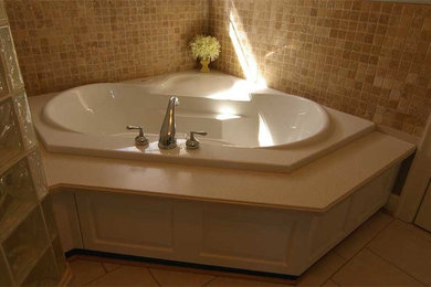 Modelo de cuarto de baño principal nórdico de tamaño medio con bañera encastrada, ducha esquinera, baldosas y/o azulejos beige, baldosas y/o azulejos de travertino, paredes beige y suelo de baldosas de cerámica