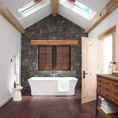 Freestanding bathtub - mid-sized country master dark wood floor freestanding bathtub idea in Denver with furniture-like cabinets, medium tone wood cabinets, wood countertops, white walls, a vessel sink and brown countertops