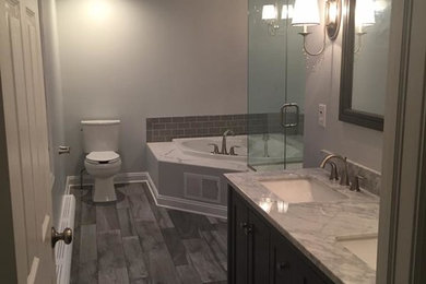 Bathroom - mid-sized transitional master gray tile and stone slab laminate floor and gray floor bathroom idea in New York with shaker cabinets, dark wood cabinets, a two-piece toilet, gray walls, an undermount sink, marble countertops and a hinged shower door