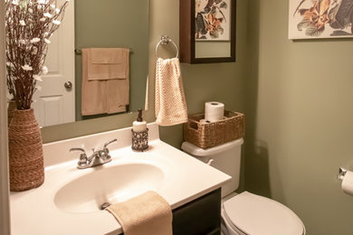 Ejemplo de cuarto de baño clásico renovado pequeño con armarios estilo shaker, puertas de armario de madera en tonos medios, suelo laminado, encimera de mármol, suelo marrón y encimeras blancas