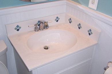 Example of a mid-sized 3/4 beige tile and stone tile ceramic tile bathroom design in Other with an undermount sink, recessed-panel cabinets, white cabinets, marble countertops and white walls