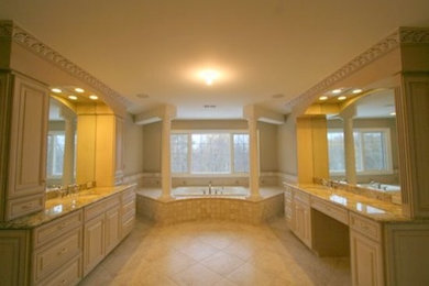 Example of a large transitional master drop-in bathtub design in Detroit with white cabinets