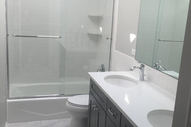 Example of a mid-sized classic 3/4 gray floor bathroom design in Chicago with shaker cabinets, dark wood cabinets, a two-piece toilet, white walls, an undermount sink and solid surface countertops