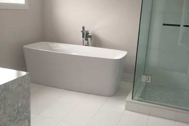 Large minimalist master white tile vinyl floor and white floor bathroom photo in Toronto with beige walls and a hinged shower door