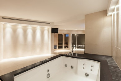 Ejemplo de cuarto de baño moderno con jacuzzi y baldosas y/o azulejos beige