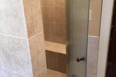 ボルチモアにある低価格の中くらいなトラディショナルスタイルのおしゃれな浴室 (コーナー設置型シャワー、ベージュのタイル、磁器タイル、開き戸のシャワー) の写真