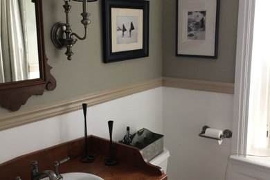 フィラデルフィアにある小さなトランジショナルスタイルのおしゃれなバスルーム (浴槽なし) (レイズドパネル扉のキャビネット、濃色木目調キャビネット、アルコーブ型シャワー、分離型トイレ、白いタイル、石タイル、グレーの壁、濃色無垢フローリング、オーバーカウンターシンク、木製洗面台、シャワーカーテン、アルコーブ型浴槽、茶色い床) の写真