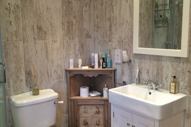 Design ideas for a large shabby-chic style ensuite bathroom in Buckinghamshire with freestanding cabinets, white cabinets, a corner shower, brown tiles and porcelain tiles.