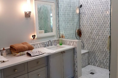 Alcove shower - large transitional master gray tile, white tile and marble tile marble floor and gray floor alcove shower idea in Other with shaker cabinets, gray cabinets, gray walls, an undermount sink, solid surface countertops, a hinged shower door and white countertops