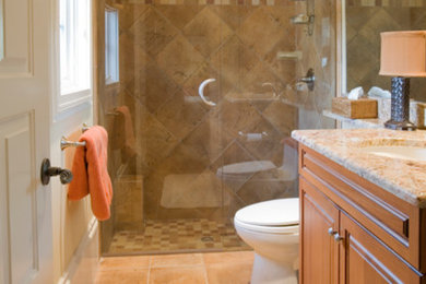 Inspiration for a large timeless master beige tile and stone tile ceramic tile and beige floor bathroom remodel in Salt Lake City with raised-panel cabinets, medium tone wood cabinets, a one-piece toilet, white walls, a drop-in sink and granite countertops