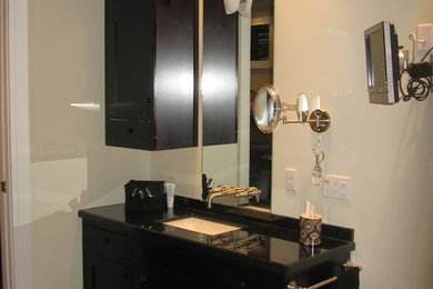 Ejemplo de cuarto de baño principal con puertas de armario de madera en tonos medios, encimera de piedra caliza, bañera exenta y baldosas y/o azulejos marrones