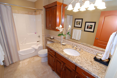 Immagine di una stanza da bagno con lavabo sottopiano, ante con bugna sagomata, ante in legno scuro, top in granito, piastrelle beige, piastrelle in pietra e pavimento in travertino