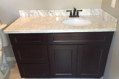 Inspiration for a contemporary bathroom remodel in New Orleans with shaker cabinets, dark wood cabinets and marble countertops