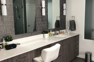 Bathroom - large contemporary master gray tile and glass tile ceramic tile and gray floor bathroom idea in Edmonton with flat-panel cabinets, medium tone wood cabinets, a one-piece toilet, white walls, an undermount sink, quartz countertops, a hinged shower door and white countertops