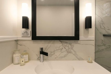 Inspiration för mellanstora moderna badrum med dusch, med marmorkakel, bänkskiva i akrylsten och en hörndusch