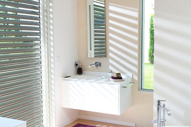 Imagen de cuarto de baño principal moderno de tamaño medio con puertas de armario blancas, bañera exenta y suelo beige