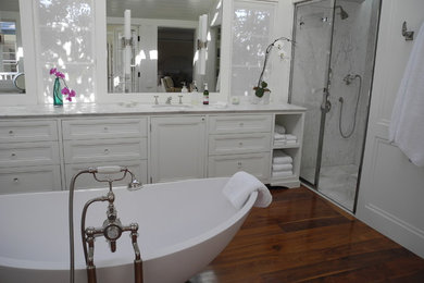 Large elegant medium tone wood floor bathroom photo in San Diego with recessed-panel cabinets, white cabinets, marble countertops and white walls