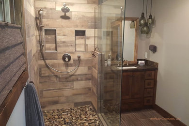 ミネアポリスにあるトランジショナルスタイルのおしゃれな浴室 (シェーカースタイル扉のキャビネット、濃色木目調キャビネット、コーナー設置型シャワー、ベージュの壁、アンダーカウンター洗面器、茶色い床、開き戸のシャワー) の写真
