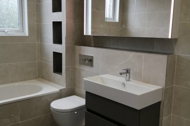 Aménagement d'une salle de bain moderne de taille moyenne pour enfant avec des portes de placard grises et des carreaux de porcelaine.