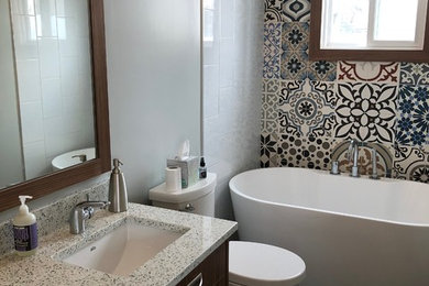 Inspiration for a small eclectic multicolored tile and cement tile ceramic tile and gray floor freestanding bathtub remodel in Calgary with flat-panel cabinets, medium tone wood cabinets, a two-piece toilet, gray walls, an undermount sink, quartz countertops and white countertops