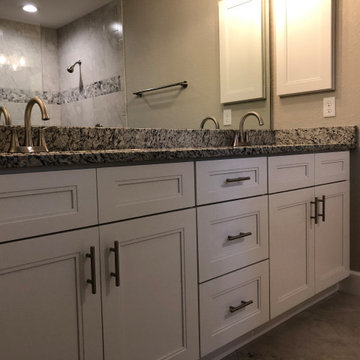 Bathroom with White Shaker-Style Cabinets and Dark Granite Countertops
