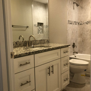 Bathroom with White Shaker-Style Cabinets and Dark Granite Countertops