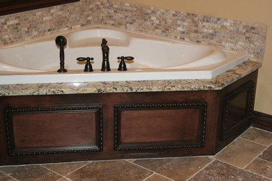 Corner bathtub - traditional beige tile and stone tile corner bathtub idea in Oklahoma City with beige walls