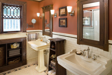 Ejemplo de cuarto de baño de estilo americano con lavabo con pedestal y parades naranjas