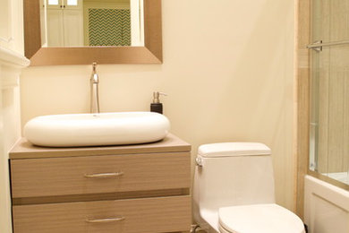 Tub/shower combo - small contemporary kids' beige tile and porcelain tile tub/shower combo idea in Toronto with a vessel sink, flat-panel cabinets, light wood cabinets, wood countertops and a one-piece toilet