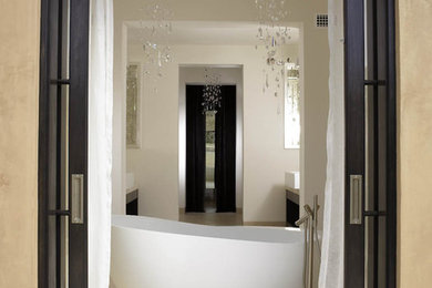 Cette image montre une salle de bain minimaliste avec une baignoire indépendante, un carrelage blanc et une porte coulissante.