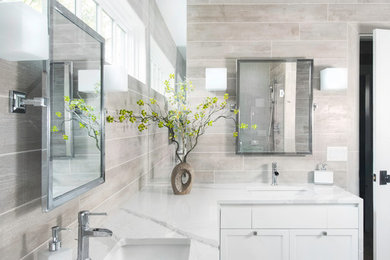 Mid-sized trendy master gray tile and porcelain tile porcelain tile and white floor walk-in shower photo in New York with recessed-panel cabinets, white cabinets, gray walls, an undermount sink, quartz countertops and a hinged shower door