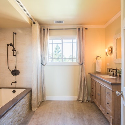 Inspiration for a large timeless beige tile and porcelain tile porcelain tile tub/shower combo remodel in San Francisco with an undermount sink, recessed-panel cabinets, quartz countertops, an undermount tub and yellow walls