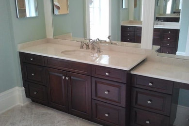 Master bathroom photo in Atlanta with a drop-in sink, recessed-panel cabinets, dark wood cabinets, granite countertops and blue walls