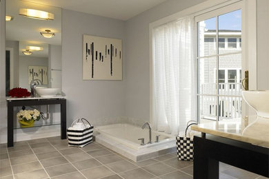 他の地域にある広いコンテンポラリースタイルのおしゃれなマスターバスルーム (家具調キャビネット、黒いキャビネット、ドロップイン型浴槽、グレーの壁、ベッセル式洗面器) の写真
