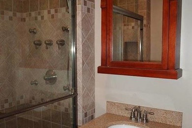 クリーブランドにあるおしゃれなバスルーム (浴槽なし) (アンダーカウンター洗面器、落し込みパネル扉のキャビネット、濃色木目調キャビネット、アルコーブ型シャワー、白い壁) の写真