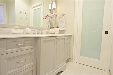 Example of a mid-sized classic 3/4 ceramic tile bathroom design in Vancouver with recessed-panel cabinets, gray cabinets, a one-piece toilet, beige walls, an undermount sink and granite countertops