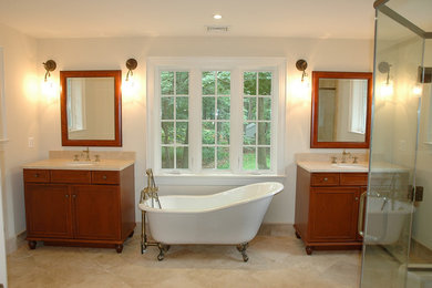Bathroom - mid-sized transitional master limestone floor and beige floor bathroom idea in Philadelphia with raised-panel cabinets, dark wood cabinets, a two-piece toilet, beige walls, an undermount sink, granite countertops and a hinged shower door