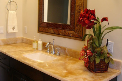Foto de cuarto de baño clásico de tamaño medio con armarios con paneles con relieve, puertas de armario de madera en tonos medios, suelo de travertino, aseo y ducha, lavabo bajoencimera y encimera de granito